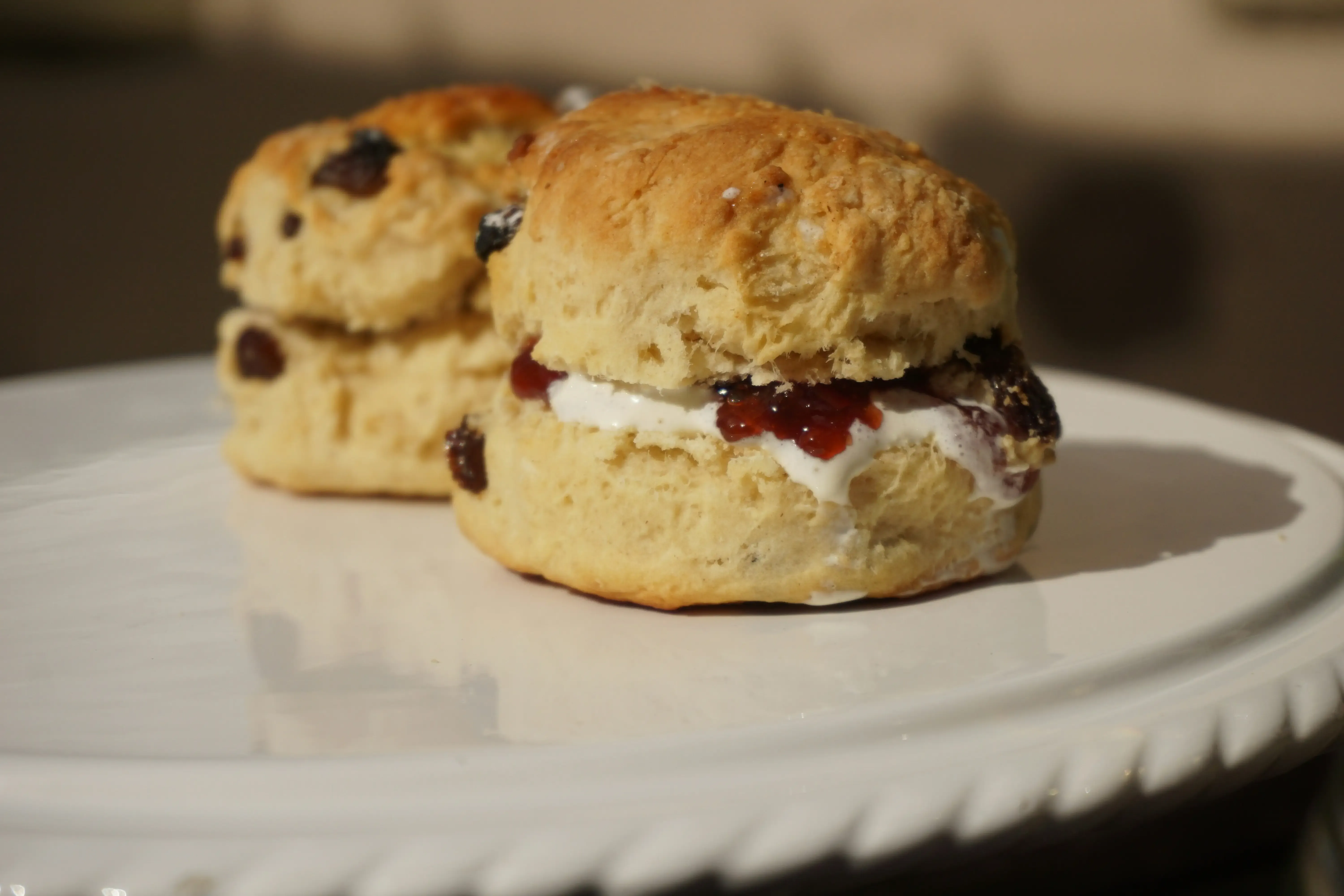 Warm scone served with strawberry jam and clotted cream